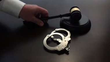 Ağır çekim koyu ahşap masa üzerinde kelepçe yanındaki aşağı tokmak çarparak yargıç