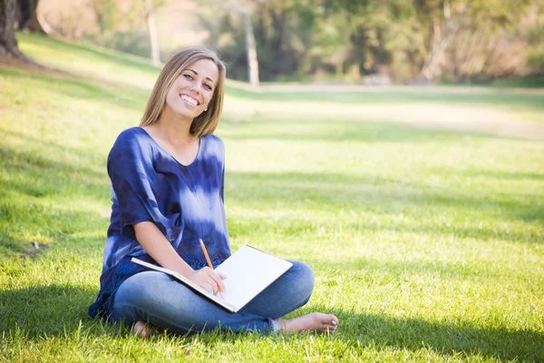 Retrato de uma bela jovem mulher com livro ao ar livre — Fotografia de Stock