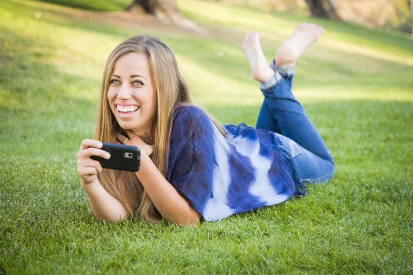 S úsměvem mladá žena pomocí mobilní telefon venku — Stock fotografie