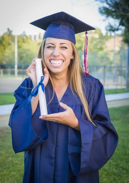 Expressive jeune femme titulaire d'un diplôme en casquette et robe — Photo