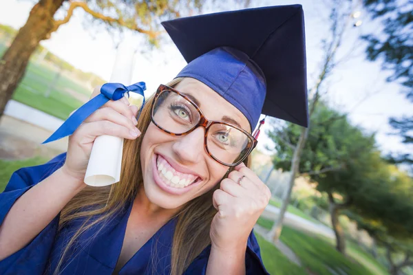 Expressive jeune femme titulaire d'un diplôme en casquette et robe — Photo