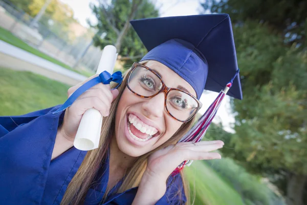 Diploma Cap ve elbise tutan etkileyici genç kadın — Stok fotoğraf