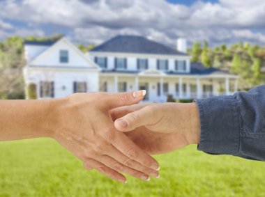Man and Woman Shaking Hands in Front of New House clipart