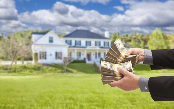 Hombre entregando cientos de dólares delante de la casa — Foto de Stock