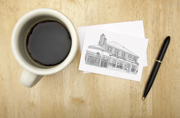 Σημείωση κάρτα με σχέδιο σπίτι, στυλό και καφέ — Φωτογραφία Αρχείου