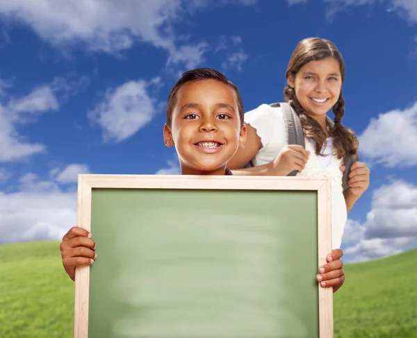 Hispanic Boy and Girl In Field Holding Blank Chalk Board — Stock Photo, Image