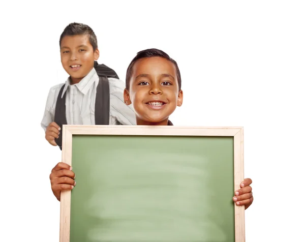 Meninos hispânicos segurando placa de giz em branco no fundo branco — Fotografia de Stock