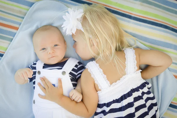 Kleine Schwester liegt neben ihrem kleinen Bruder auf Decke — Stockfoto