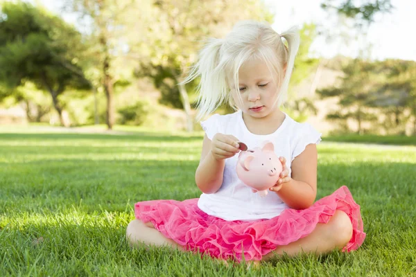 어린 소녀가 밖에 서 그녀의 돼지 저금통과 재미 — 스톡 사진
