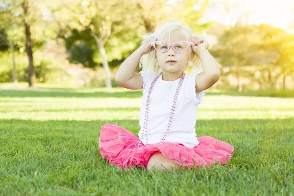 Petite fille jouant robe avec des lunettes roses et collier — Photo