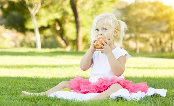 Ragazzina in erba mangiare mela sana — Foto Stock