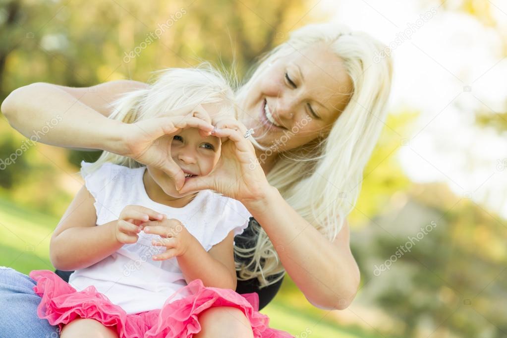 Little Girl With Mother Making Heart Shape with Hands
