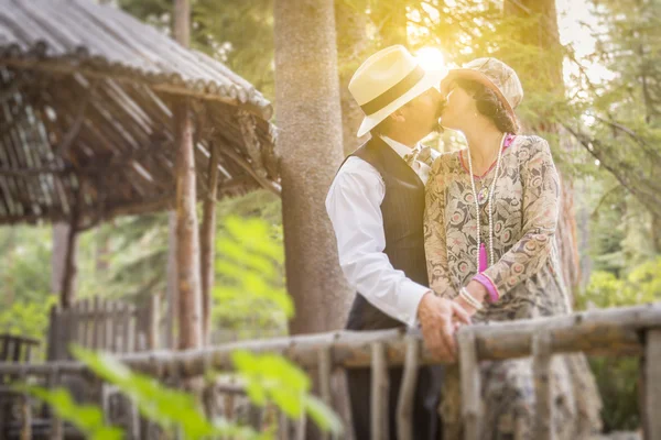 1920 vestita coppia romantica baciare sul ponte di legno — Foto Stock
