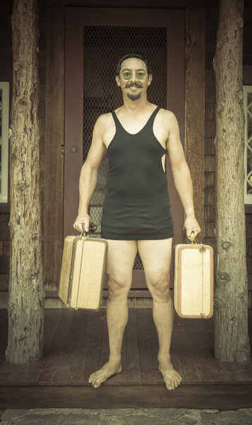 Gentleman Dressed in 1920s Era Swimsuit Holding Suitcases on