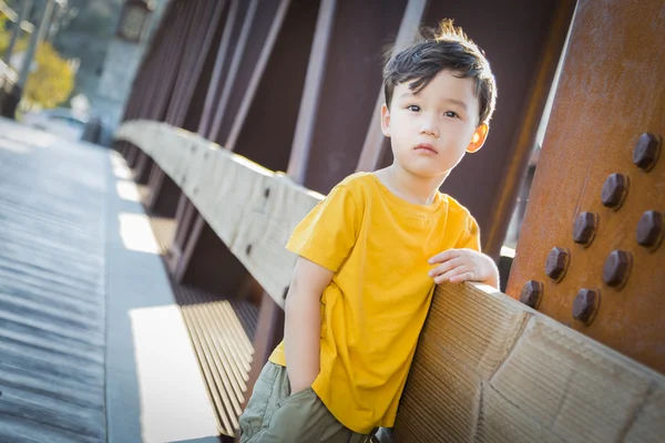 Mixed Race Boy Leaning on Bridge Outdoors — Stock Photo, Image