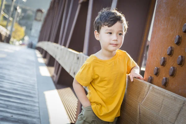 Mixed Race Boy Leaning on Bridge Outdoors — Stock Photo, Image