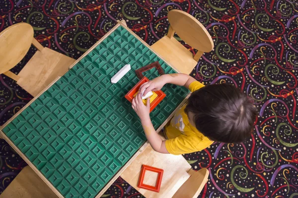 Frais généraux de garçon jouant avec ses jouets à la table — Photo