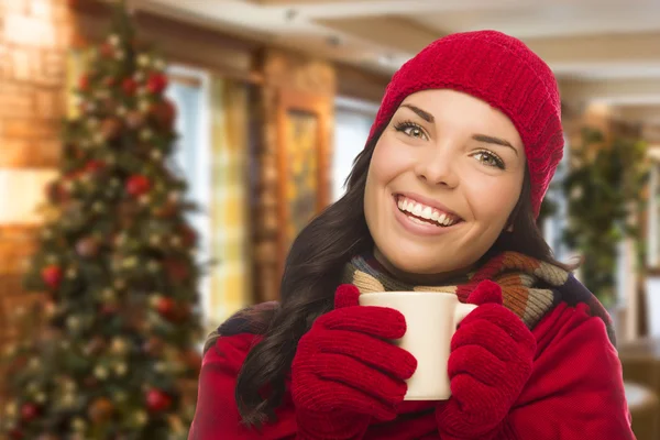 Mujer de raza mixta que usa sombrero y guantes en el entorno de Navidad —  Fotos de Stock