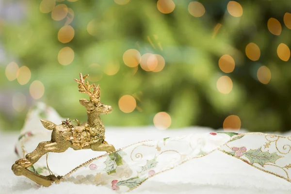 Christmas Reindeer Ornament, Ribbon on Snow with Tree and Lights — Stock Photo, Image