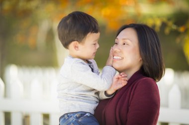 Chinese Mom Having Fun and Holding Her Mixed Race Boy clipart
