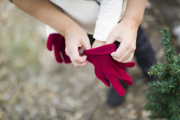 Μητέρα βάζοντας κόκκινο γάντια σε παιδί — Φωτογραφία Αρχείου