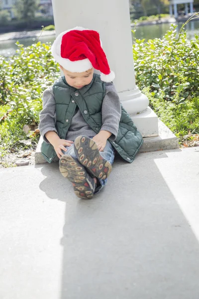 Melancolía mezclado raza chico usando Navidad santa sombrero —  Fotos de Stock