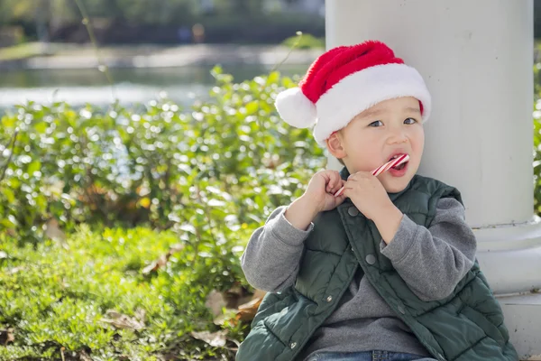 可爱的混的血男孩与圣诞老人的帽子和糖果手杖 — 图库照片