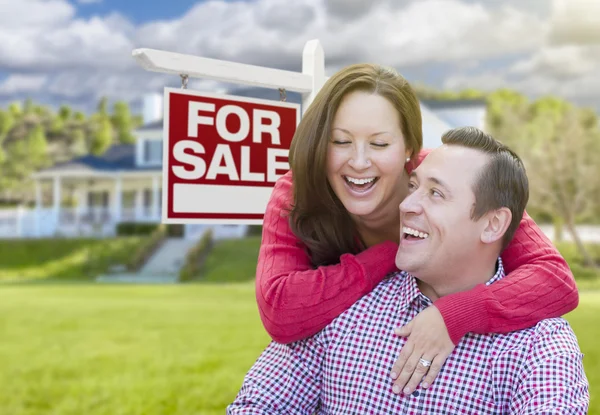 幸福的夫妇的前面出售标志和房子 — 图库照片