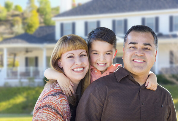 Happy Mixed Race Young Family in front of House
