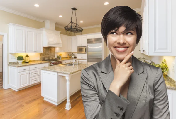 Mujer de raza mixta mirando hacia atrás por encima del hombro dentro de Kitche personalizado — Foto de Stock