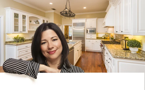 Mulher hispânica encostada ao branco na cozinha interior personalizada — Fotografia de Stock