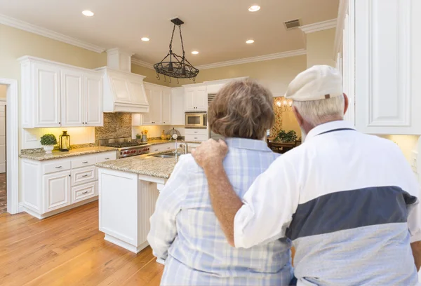 Coppia anziana guardando oltre bella cucina personalizzata — Foto Stock