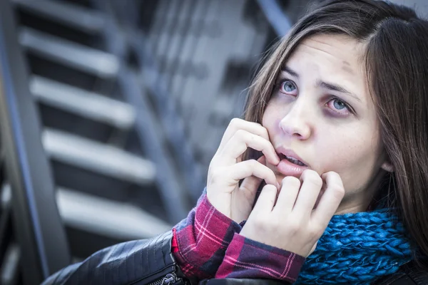 Young mörbultad och skrämde flickan på trappan — Stockfoto