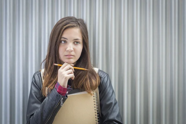 Giovane malinconia studentessa con libri guardando al lato — Foto Stock