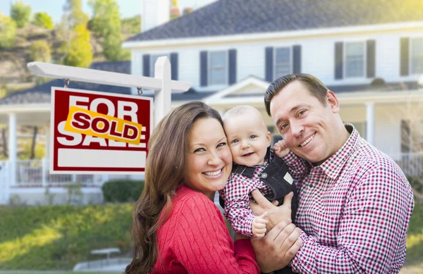Jonge gezin voor voor verkoop teken en huis — Stockfoto