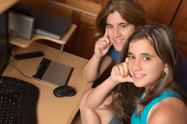 Adolescente e sua mãe ao lado de um computador — Fotografia de Stock