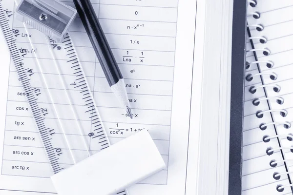 Utensilios escolares y un libro de matemáticas con un tinte azul — Foto de Stock