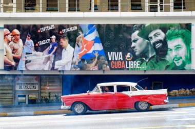 Bir Pano Havana'da devrimci sloganlar yanındaki eski araba