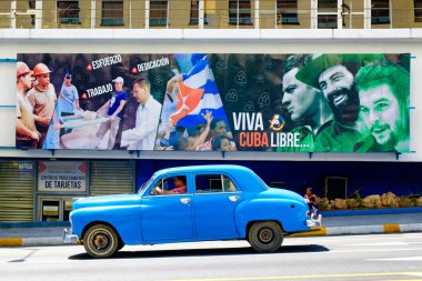 Bir Pano Havana'da devrimci sloganlar yanındaki eski araba