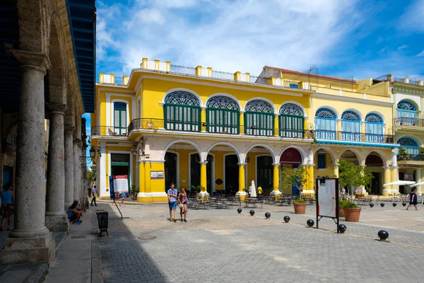 Turistas e moradores em uma praça colorida em Old Havana — Fotografia de Stock