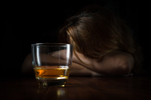 Alcohol addicted  woman with a glass of whisky