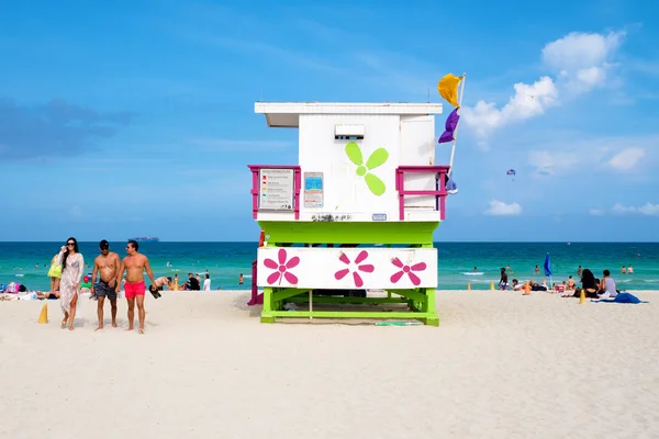 Jonge mensen genieten van het strand naast een kleurrijke badmeester tow — Stockfoto
