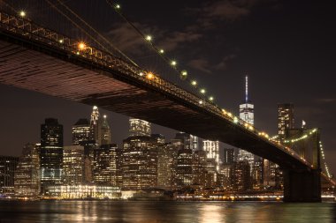 Şehir merkezindeki Manhattan siluetinin ve gece Brooklyn Köprüsü