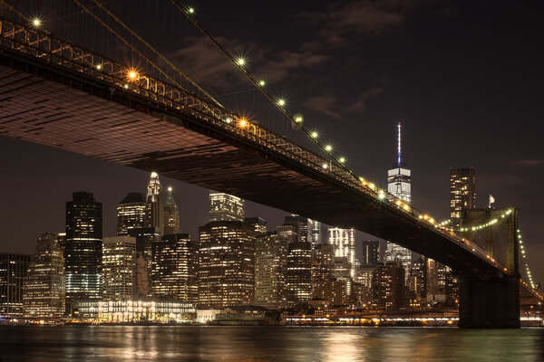The skyline of downtown Manhattan and the Brooklyn Bridge illuminated at night