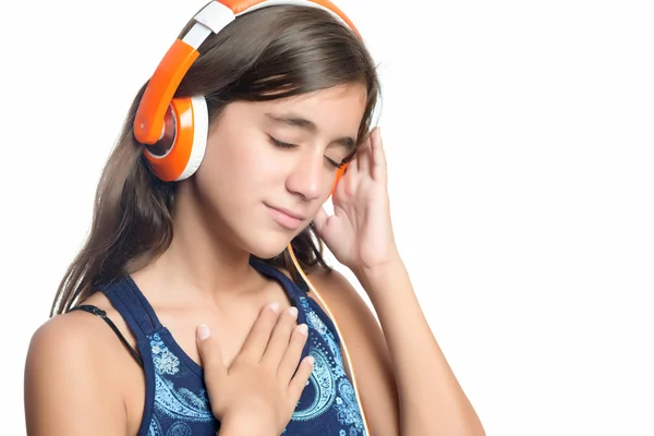 Menina adolescente hispânica bonita desfrutando de música em fones de ouvido laranja brilhante — Fotografia de Stock