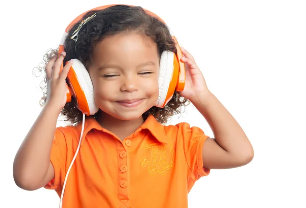 Маленькая девочка с африканской прической наслаждается музыкой на ярко-оранжевых наушниках — стоковое фото