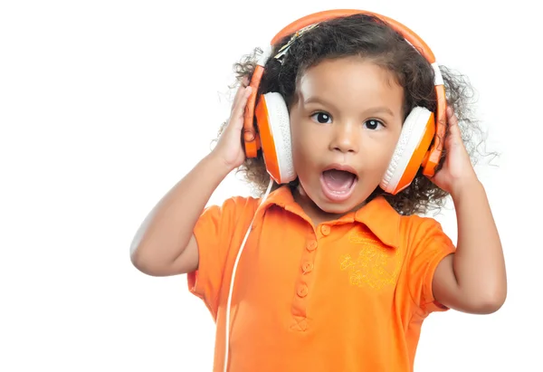 Menina animada com um penteado afro desfrutando de sua música em fones de ouvido laranja brilhante — Fotografia de Stock