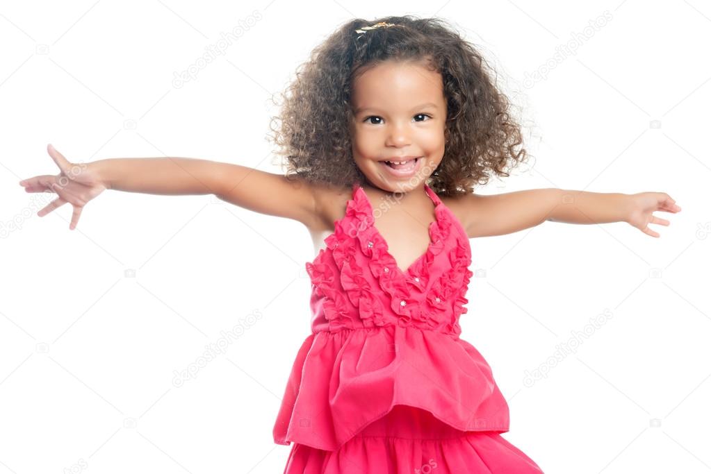 Lttle girl with an afro hairstyle laughing with her arms extended