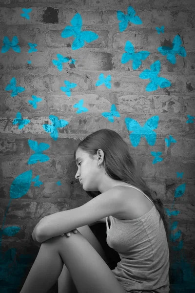 Sad teenage girl with blue butterflies — Stock Photo, Image
