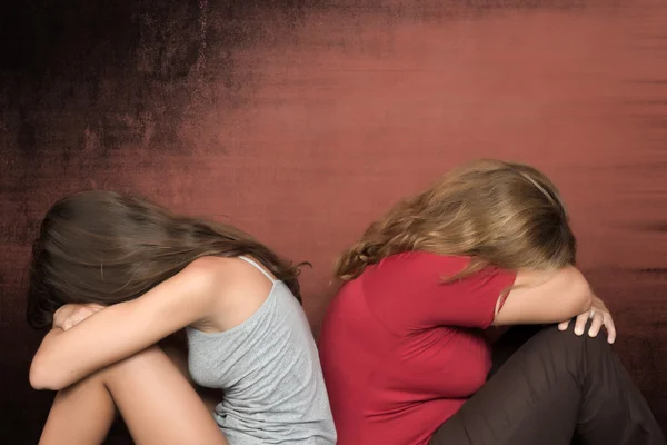 Teen daughter and mother sitting on the floor crying — Stock Photo, Image